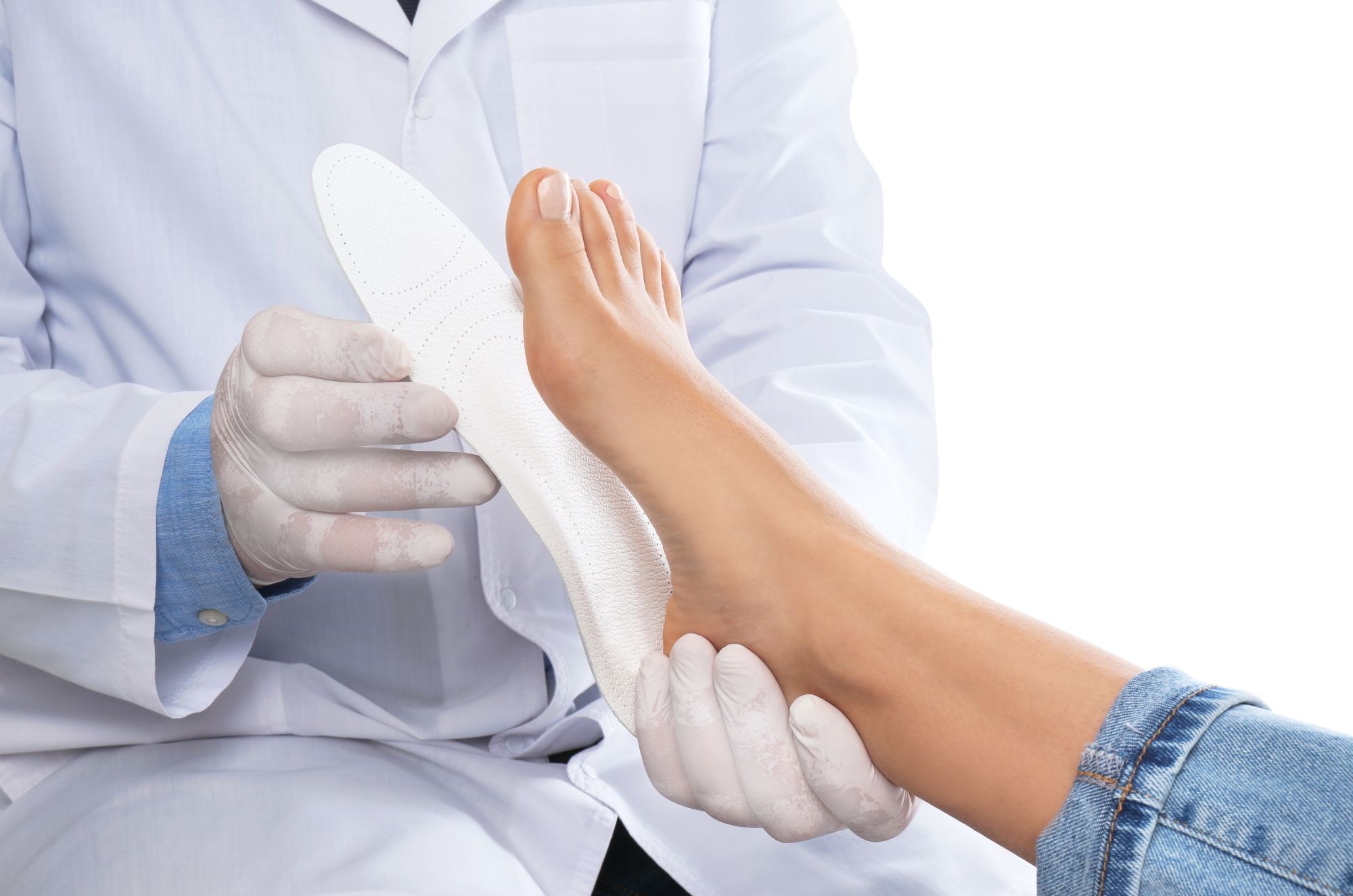 A Doctor Fitting Orthotics To Patient's Foot